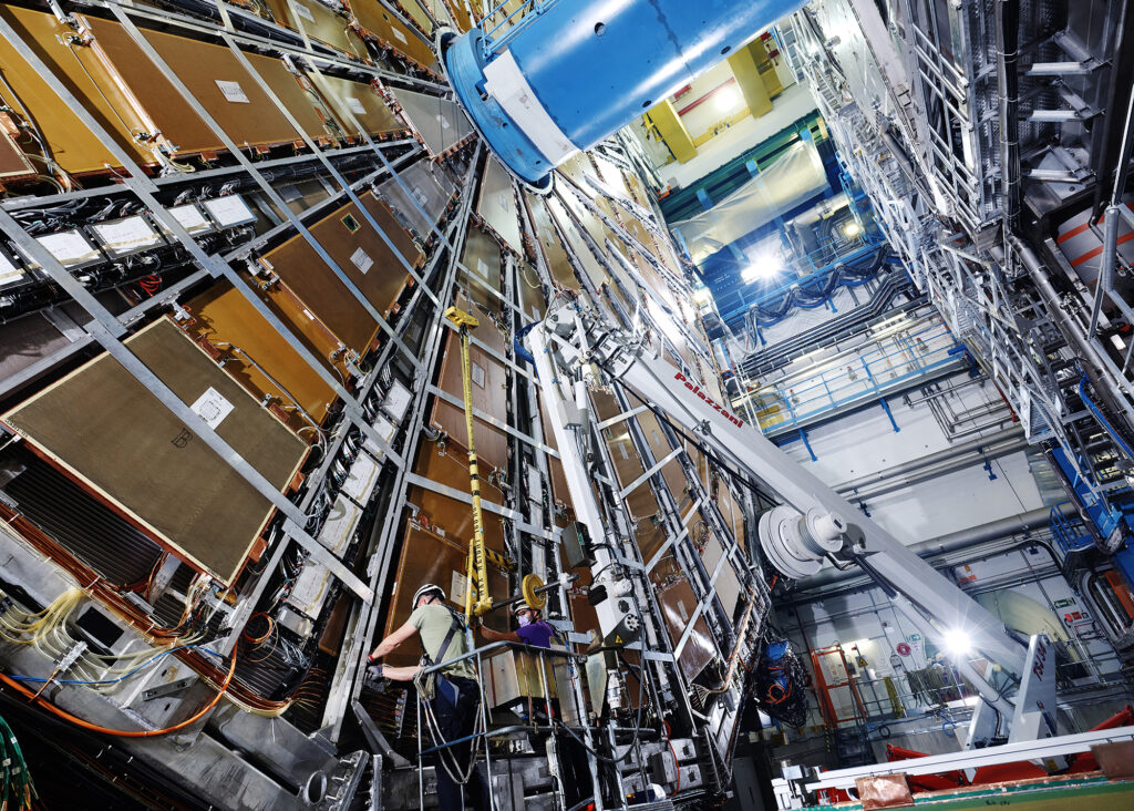 An engineer works on the ATLAS detector, a 20-metre tall cylindrical particle detector.