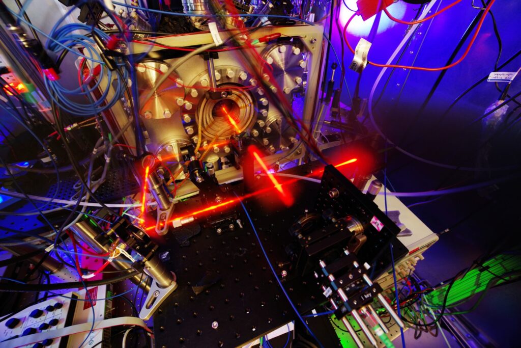 A brightly-shining red laser rebounds within a small room filled with experimental apparatus.