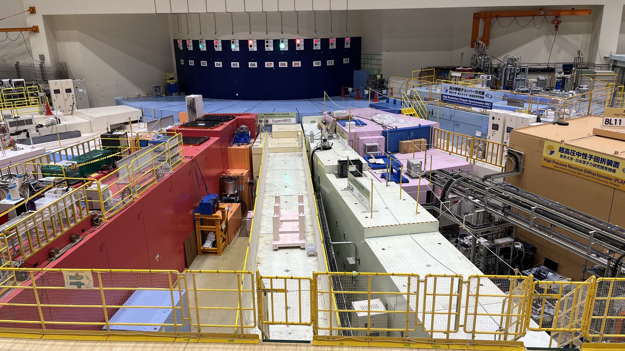 A series of particle accelerator and detector modules arranged in a circular fashion in a large warehouse-type room.